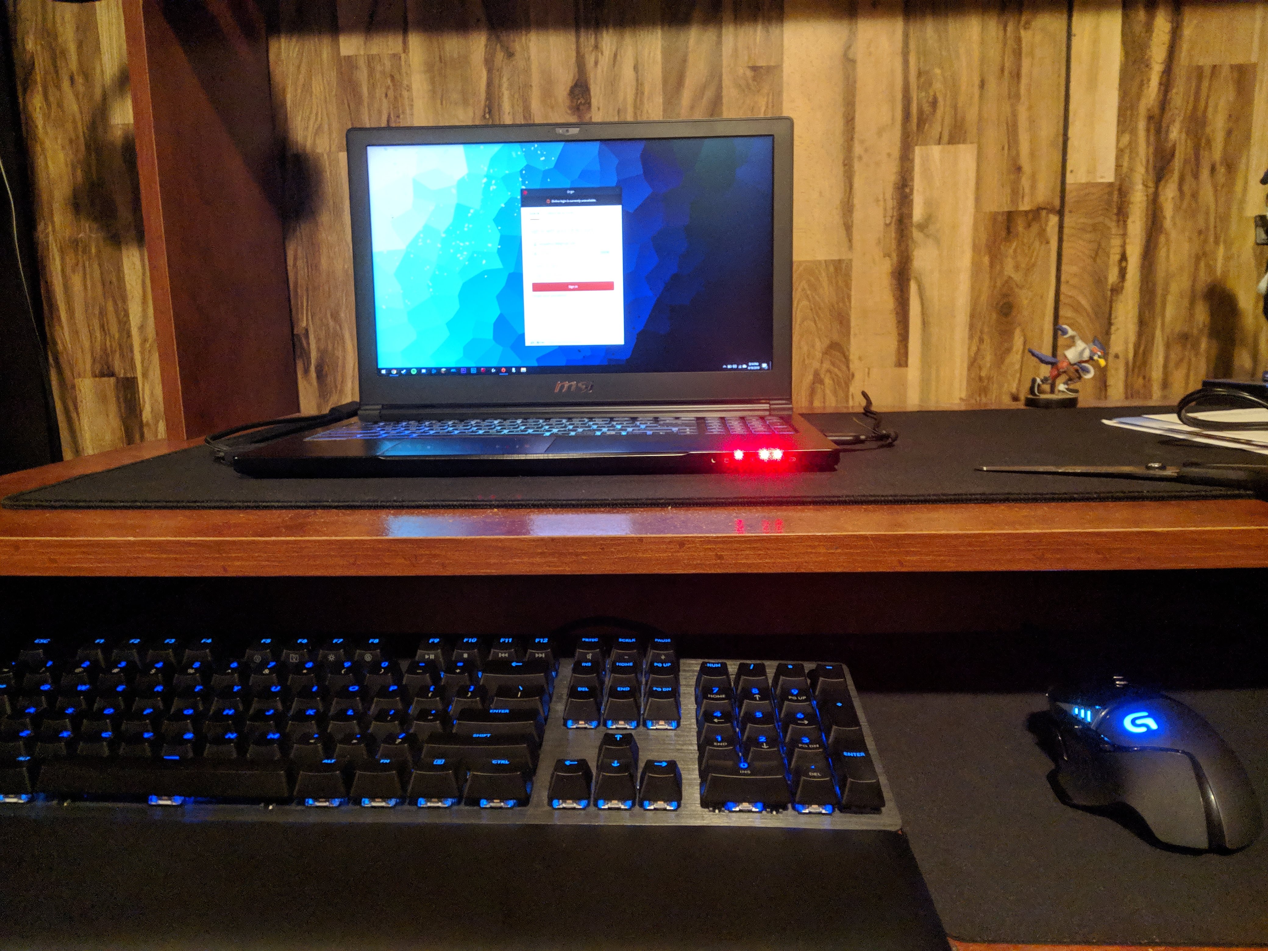 The picture shows an MSI GS63VR gaming laptop and logitech peripherals. The components have blue RGB lighting.