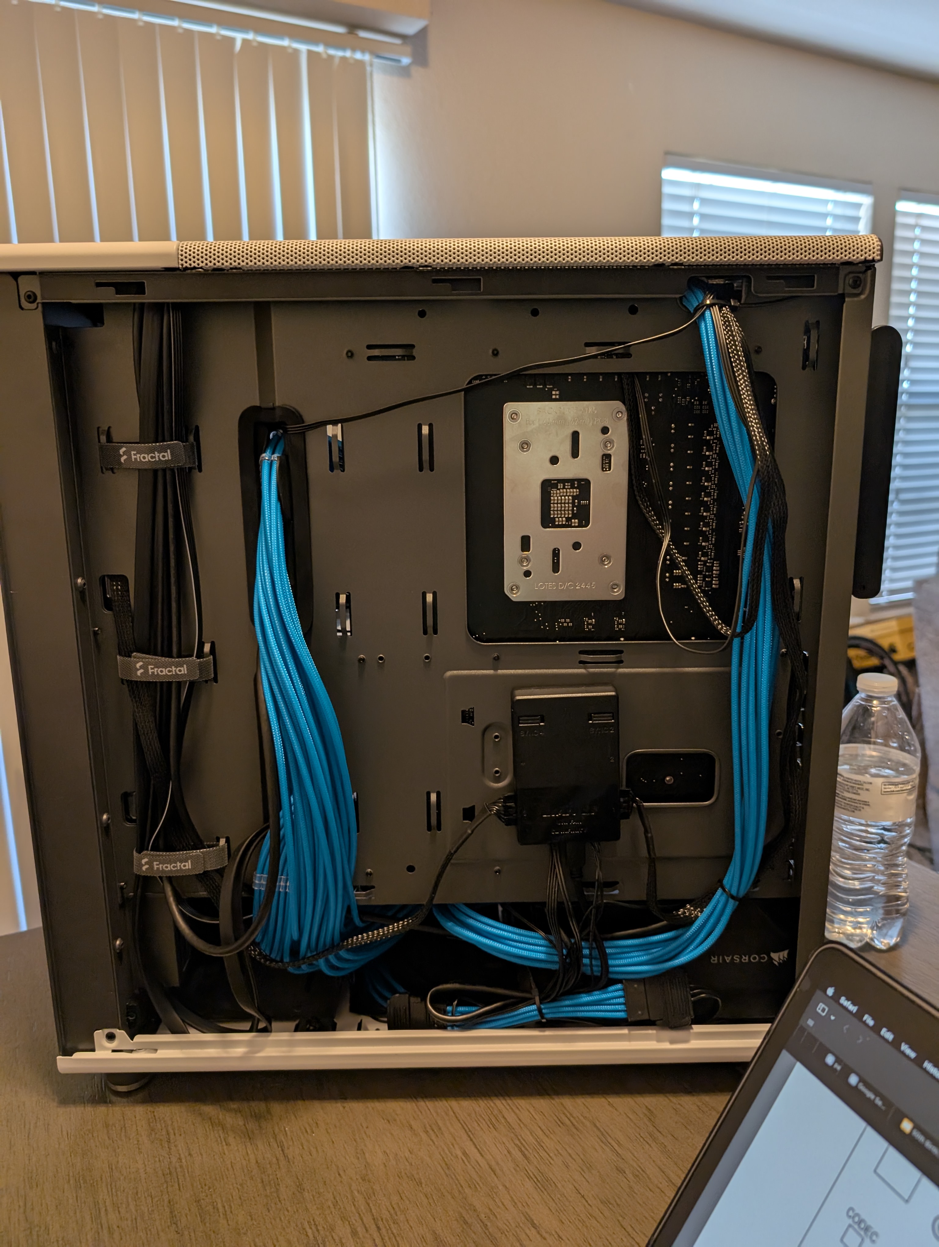 The picture shows the back of the computer, highlighting the manner in which the power, data, and RGB cables are routed.